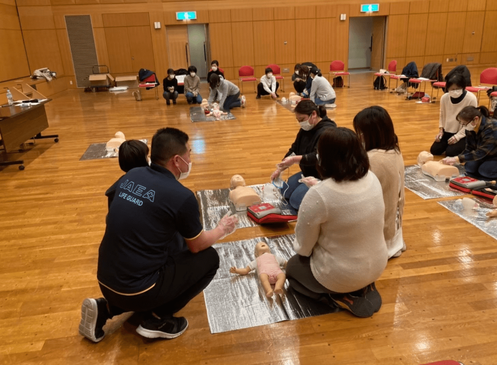 数名の女性が心肺蘇生法を教えてもらっている