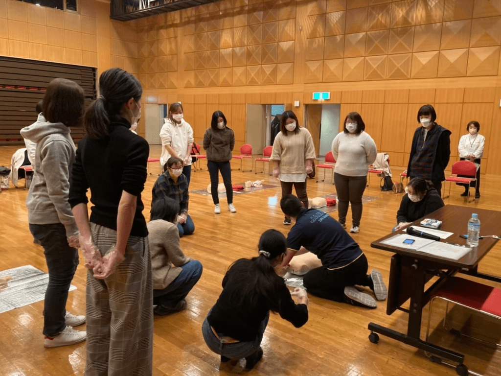 数名の女性が心肺蘇生法を教えてもらっている