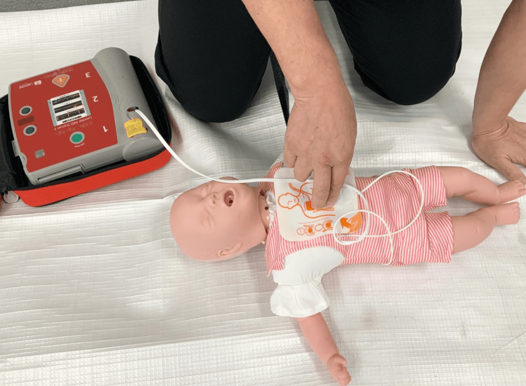 乳児の人形でAEDの練習をしている