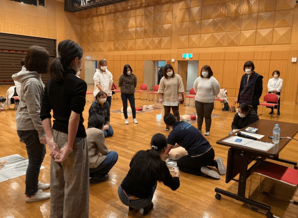 数名の女性が心肺蘇生法を教えてもらっている