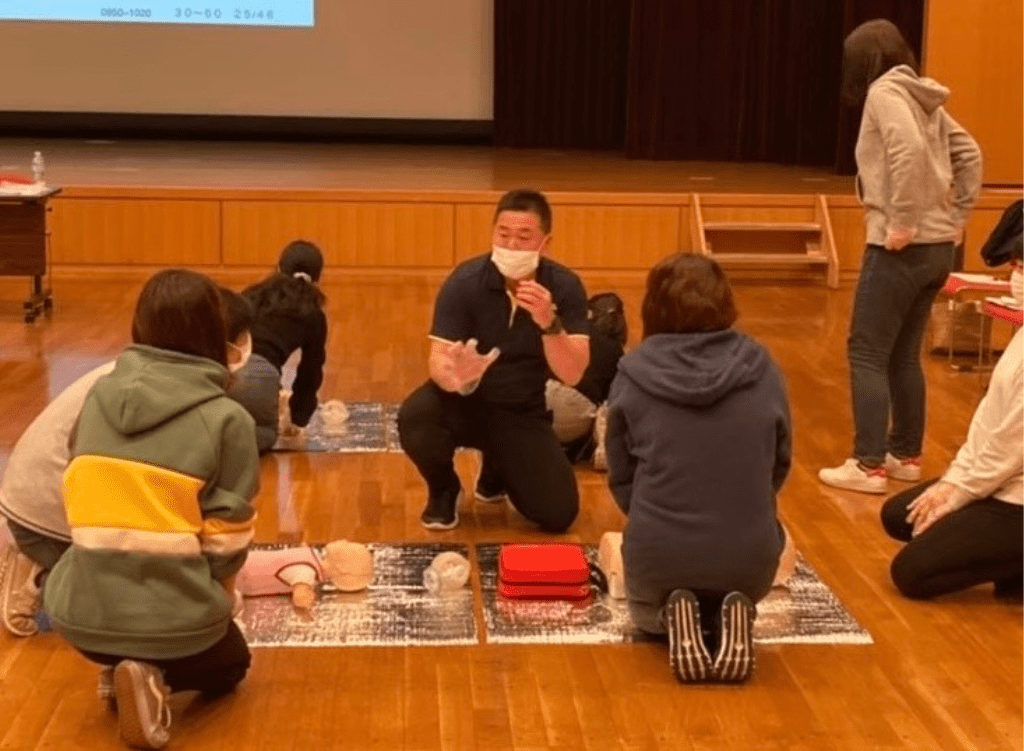 数名の女性が心肺蘇生法を教えてもらっている